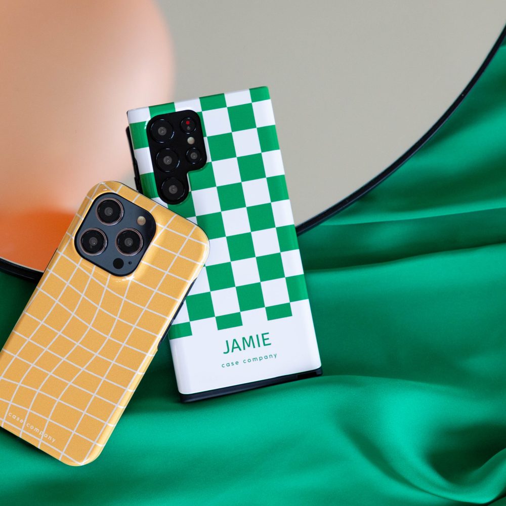Dve odolné puzdrá: žlté kockované na iPhone a zelené s blokovým vzorom a menom Jamie